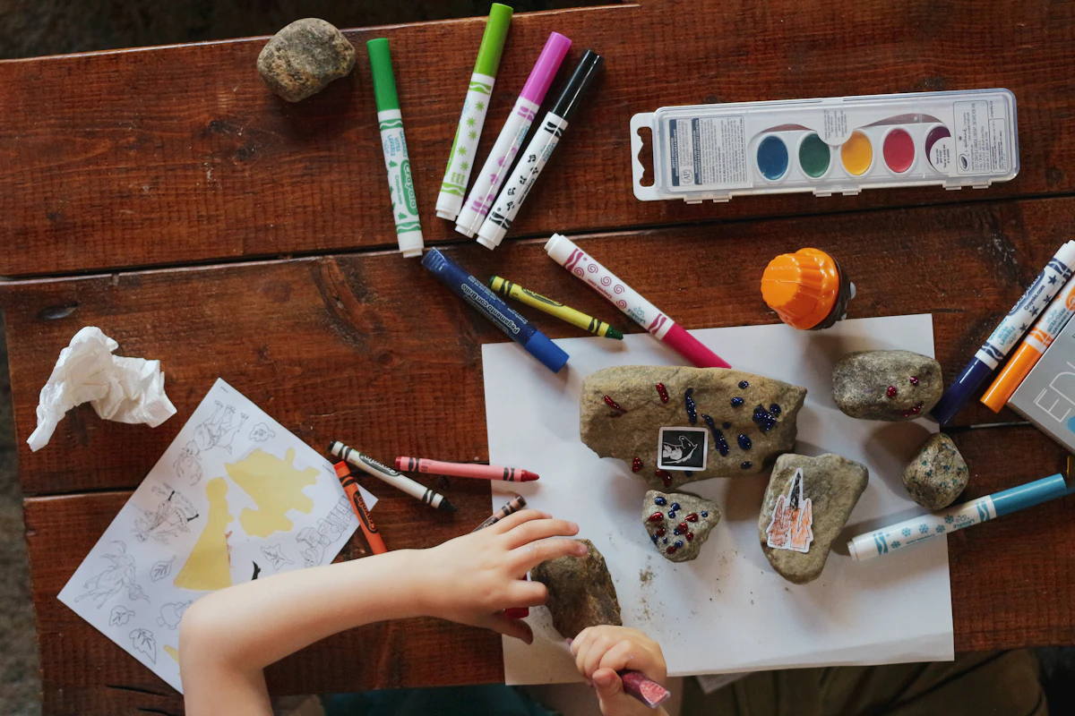 A craft table with markers, watercolors and art supplies